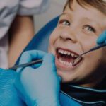 child smiling at dentist while teeth is getting looked at