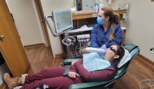 woman lying on the dental chair getting her teeth checked by a dentist