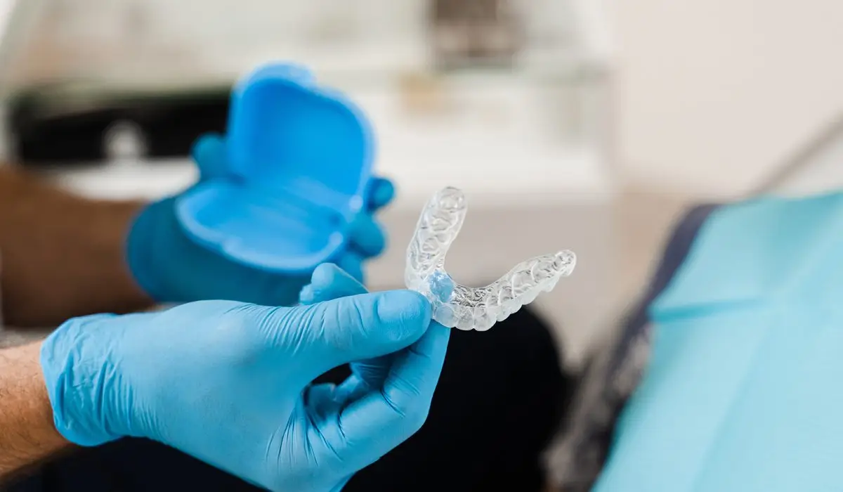 Orthodontist shows transparent removable retainer. Clear aligner for bite correction and shape of teeth.