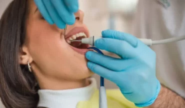 Close-up of dental hygienist treating young woman’s mouth to prevent emergency caused by advanced tooth decay.