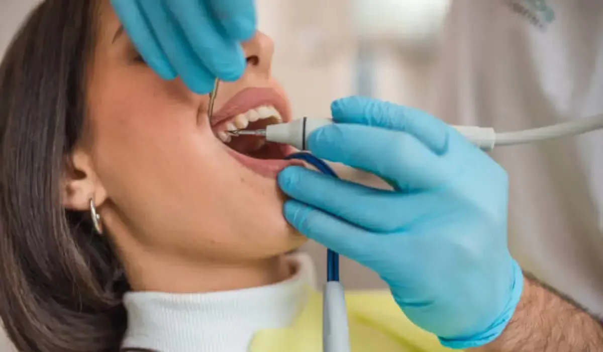 Close-up of dental hygienist treating young woman’s mouth to prevent emergency caused by advanced tooth decay.