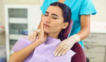 Woman with tooth pain during emergency visit caused by tooth decay